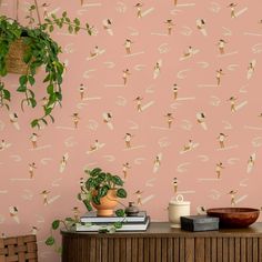 a pink wall with some plants on top of it