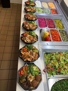 a buffet line filled with lots of different types of salads and other food items