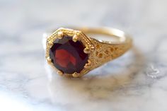 Metal: 14kt Yellow Gold Stone: Garnet Shape: Round Garnet Weight: 1.65 ctw Ring Size: 5 1/2 Sizing: Please state ring size in the personalization box. Weight of entire piece with stones: 3.50grams Width Of Top Part Of Ring : 10mm Customization: We can custom make this ring with any gems and metals. Please inquire if interested. White Gold Amethyst Version: https://www.etsy.com/listing/231479258/sale-vintage-style-14k-white-gold?ref=shop_home_active_7&frs=1 Rose Gold Aquamarine Version: https Garnet Engagement Rings, Gold Garnet Ring, Traditional Engagement, Gothic Engagement Ring, Garnet Engagement Ring, Ring Inspo, Hand Rings, Ruby Rings, Traditional Engagement Rings