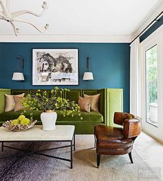 a living room with blue walls and green furniture