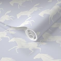 a wallpaper with horses on it in grey and white colors, as well as a roll of tape