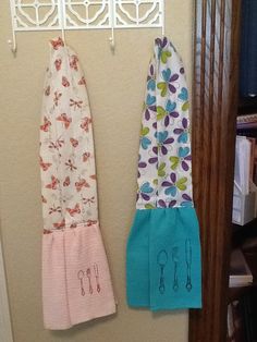 two kitchen towels hanging on the wall next to a rack with utensils in it