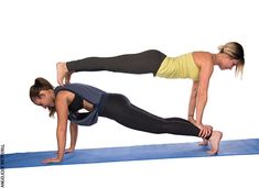 two women doing push ups on yoga mats