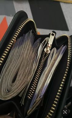 an open black purse with multiple zippers on it