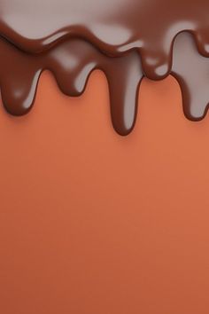 chocolate flowing down the side of an orange wall with brown and white paint on it