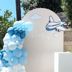 an airplane balloon arch with blue and white balloons