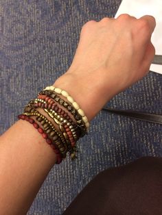 a person's arm with several bracelets on it