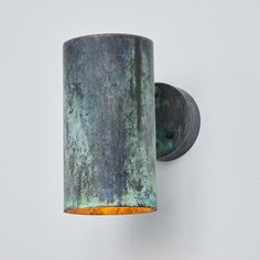 a wall mounted light that is on the side of a wall with a rusted metal finish