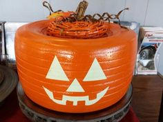 an orange pumpkin shaped planter sitting on top of a wooden table next to other items