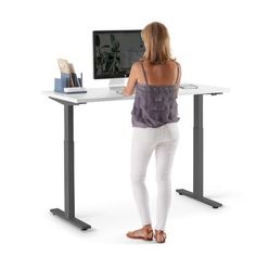 a woman standing in front of a computer desk