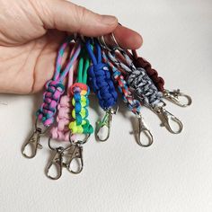 a hand holding several different colored lanyards