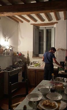 a man standing in a kitchen preparing food on top of a counter next to an oven