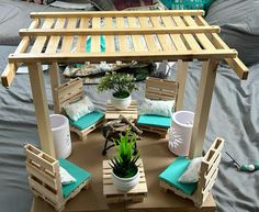 a wooden gazebo sitting on top of a bed covered in blue pillows and blankets