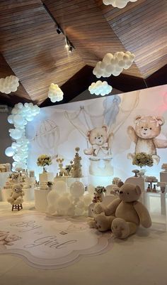 there are many teddy bears on display in this room with balloons and lights hanging from the ceiling