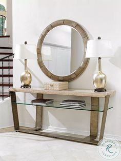 a table with two lamps and a round mirror on the wall in front of it