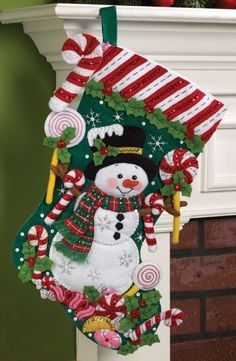 a christmas stocking with a snowman and candy canes hanging from it's side