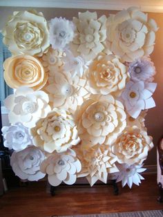 an arrangement of paper flowers is displayed on the wall