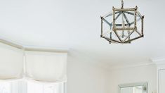 a bathroom with white walls and a mirror hanging from the ceiling