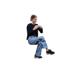 a woman sitting on top of a chair while holding a cell phone in her hand