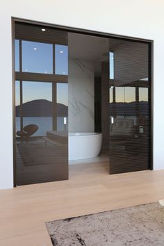 an empty bathroom with a tub and large glass doors