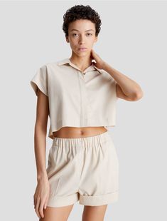 Structured in a boxy fit, this cropped button-down shirt is a lightweight piece perfect for warmer days. Designed with short sleeves and a crisp point collar. Features hidden button closures along the front and finished with Calvin Klein logo styling at the back.  Material: 98% Lyocell, 2% Elastane. Cropped Button Down, Calvin Klein Woman, Fashion Logo, Women Crop, Button Downs, Calvin Klein, Button Down Shirt, Short Sleeves, Women Wear