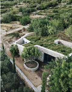 an aerial view of a building with plants growing on the roof and trees around it