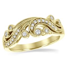 a yellow gold ring with diamonds on the sides and an intricate design in the middle