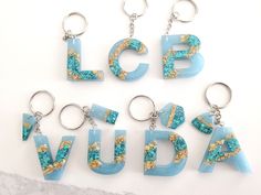 the letters are made out of glass and have gold glitters on them, as well as blue acrylic paint