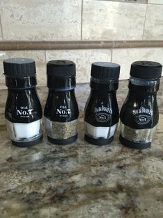 three bottles of seasoning sitting on top of a counter