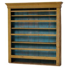 an old wooden bookcase with blue glass inserts on the front and bottom shelves