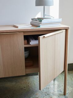 a table with a lamp and books on top of it next to a book shelf