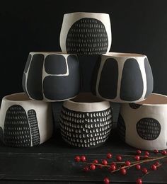 five black and white vases sitting next to each other on top of a table