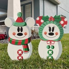 two snowmen are standing in the grass