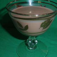 a glass filled with milk sitting on top of a green table