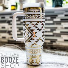 a gold and white coffee mug sitting on top of a counter