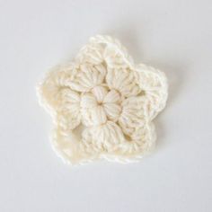 a crocheted flower on a white surface