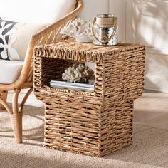 a wicker end table with a magazine rack and vase on top in a living room