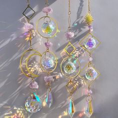 the sun shines brightly through several different pieces of jewelry hanging from chains and necklaces