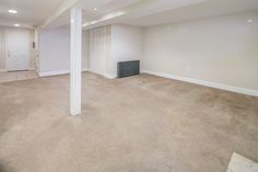 an empty living room with carpeted floors and white columns in the center, along with a radiator