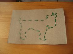 a piece of paper that has been made to look like a cow with green thread on it