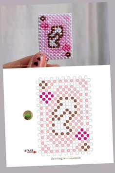 someone is holding up a cross stitch bead pattern to show how it looks like