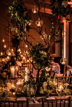 the table is set with candles, greenery and glassware for an elegant dinner