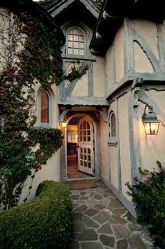 the entrance to an old style house with stone walkway