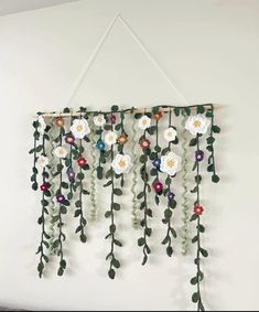 a white wall hanging with flowers and leaves