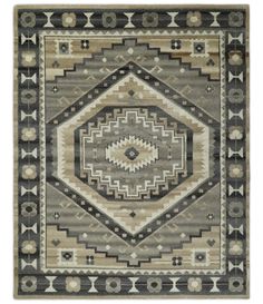 a rug with an abstract design in grey, beige and black colors on the floor