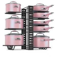 pink pots and pans are stacked up on black shelves with metal racks holding them