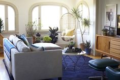 a living room filled with furniture and plants