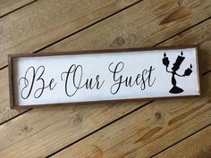 a wooden sign that says be our guest