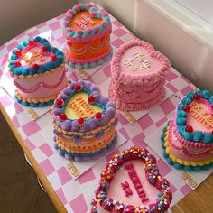 a table topped with lots of cakes covered in frosting