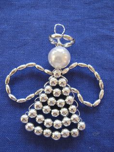 a brooch with pearls on it sitting on a blue cloth